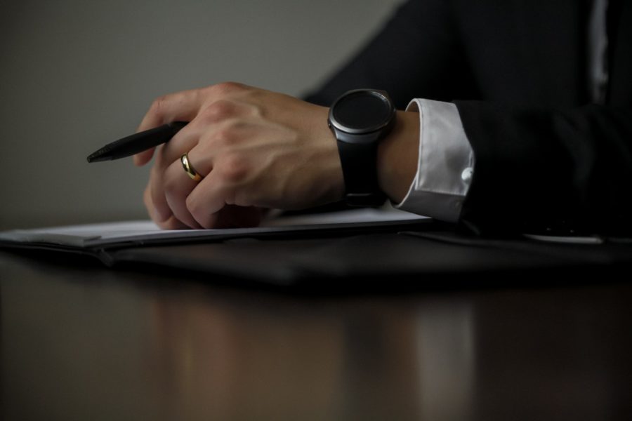 Lawyer holding a pen and paper on table.