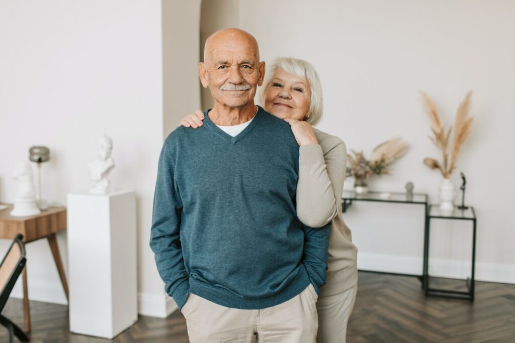 Elderly couple smiling together in home.
